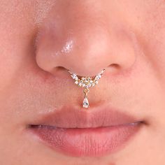 a woman's nose has a gold nose ring with three small diamonds on it