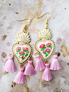 two pink tasselled heart shaped earrings with roses on them, hanging from gold hooks