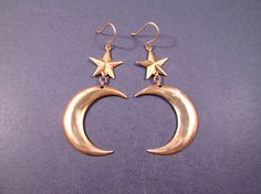 a pair of earrings with stars hanging from them