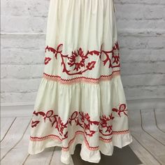 Long Skirt With Beautiful Embroidery And Red Trim. White Embroidered Maxi Skirt For Spring, White Embroidered Full Skirt, Traditional Lined Skirt For Spring, Traditional Tiered Maxi Skirt For Spring, White Flared Skirt With Floral Embroidery, White Embroidered Long Skirt, White Floral Embroidered Skirt, Embroidered Hem Flowy Long Skirt, Red Floral Embroidery Skirt For Spring