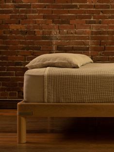 a bed that is in front of a brick wall