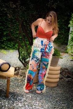 Look like paradise with our ISLAND GAL | FRINGE PANTS. Featuring a tropical print with fringe accents, these super sexy pants will make a bold statement with their vibrant colors and eye-catching prints. Embrace your inner island goddess and turn heads wherever you go! DETAILS & FIT Non-stretch pants High-waisted Elastic waistband Pockets Flared Cuffed ankles CONTENTS & CARE Inseam is 30 inches 90% Polyester 10% Spandex Hand wash cold Do Not Dry Bohemian Tropical Print Bottoms For Spring, Bohemian Bottoms With Tropical Print For Spring, Vibrant Print Pants For Vacation, Bohemian Bottoms With Vibrant Print For Vacation, Bohemian Vibrant Print Vacation Bottoms, Summer Bottoms With Tassels For Beach Season, Beachwear Fringe Bottoms For Vacation, Beachwear Bottoms With Fringe For Vacation, Fringe Bottoms For Beach Vacation