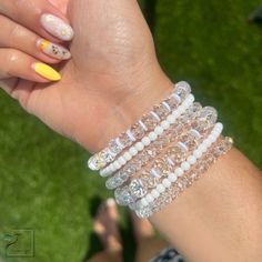 Adorn your arms with this stunning combination of white, crystal and gold-toned bracelets. Crafted to evoke a timeless elegance, these precious accessories are the perfect blend of minimalist sophistication and classic luxury. Material :* 4mm gold plated beads * charms * crystal beads *4mm matte beads • Bracelets are custom-crafted according to size; if the desired size isn't listed below, please contact me for assistance. • Processing Time is an estimated 3-5 business days (does not include wee Elegant Adjustable Clear Beaded Bracelets, Elegant Clear Beaded Bracelets With Adjustable Fit, Elegant White Beaded Stretch Bracelet, Elegant Crystal Bracelet With Rhinestones, Elegant White Beaded Crystal Bracelet, Dainty White Round Charm Bracelet, White Pearl Beaded Charm Bracelet, White Pearl Jewelry With Rhinestones, Elegant White Crystal Bracelet With Spacer Beads