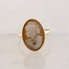 10K Yellow Gold Shell Cameo Ring, woman looking left wearing a necklace, small accent stone to center, Ring size 7, 3.72 gramsStock # BB302R02Most rings are sizable for a small fee. If the ring you are considering is the incorrect size contact us for a quote.This listing contains photographs of the actual item you will receive. Our items are in excellent condition with little or no signs of wear and many are one of a kind pre-owned estate finds. Please look closely at the pictures in this listin Timeless White Gold Jewelry With Cabochon, Classic Oval Cameo Rings, Elegant Rings With 17 Jewels, Elegant Oval Cameo Jewelry, Formal Yellow Gold Cameo Jewelry, Cameo 14k Gold Rings For Anniversary, Cameo 14k Gold Ring, Cameo 14k Gold Round Jewelry, 14k Gold Cameo Round Jewelry