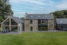 a stone house sitting on top of a lush green field