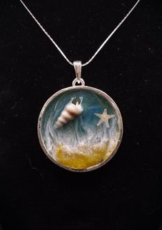 a necklace with an image of a hand holding a star in the sky on it