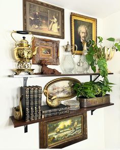 a shelf with books, vases and pictures on it