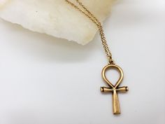 The Egyptian Ankh symbolizes life, protection & eternity. Its power was believed to protect the dead and ensure eternal life. Wear a piece of Ankh jewelry for protection, a reminder of the past, or just as an accessory. Materials: 1” pewter charm with 18" gold plated brass chain Made in USA Spiritual Jewelry With Antique Finish, Spiritual Antique Gold Jewelry With Antique Finish, Spiritual Brass Jewelry With Oxidized Finish, Symbolic Ankh-shaped Metal Jewelry, Symbolic Ankh Shaped Metal Jewelry, Symbolic Bronze Jewelry, Spiritual Antique Finish Jewelry, Antique Gold Symbolic Engraved Jewelry, Spiritual Antique Finish Jewelry As A Gift