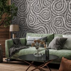 a living room with a green couch and coffee table in front of a patterned wall