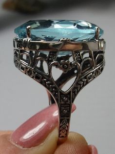 24ct. Simulated Aquamarine Sterling Silver RingOval Beast Design#D76 This is a new beautiful Victorian reproduction ring cast in solid sterling silver. The gorgeous filigree ring is set with a huge approximately 24 carat simulated blue aquamarine gemstone. The stunning gem is 17mm (11/16") wide x 23mm(15/16") long. The ring is 12mm off the finger. The inside of the band is marked 925 for sterling silver. Notice the craftmanship of the sterling silver setting. The large stone is accented by the b Formal Oval Ring With Intricate Design, Formal Oval Engraved Filigree Ring, Oval Topaz Art Deco Ring For Formal Occasions, Oval Art Deco Topaz Ring For Formal Occasions, Formal Sterling Silver Filigree Ring With Polished Finish, Silver Filigree Ring With Polished Finish For Wedding, Art Deco Oval Filigree Ring With Gemstone, Unique Oval Rings For Formal Occasions, Antique Oval Filigree Ring Gift