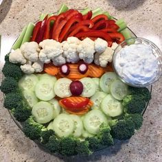 a platter filled with vegetables and veggies as a face