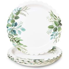 two white plates with green leaves on them