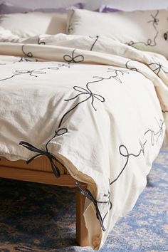 a bed with white sheets and black bows on it