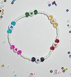 a white bracelet with multicolored hearts on it's beaded string and beads