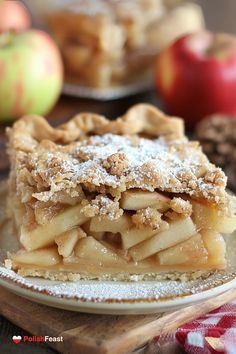 an apple pie with powdered sugar on top sits on a plate next to other desserts