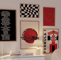 a white dresser sitting next to a wall covered in pictures and framed art on it