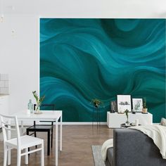 a living room filled with furniture next to a wall covered in green and white waves