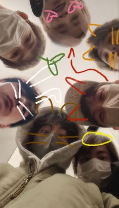 four people wearing face masks and looking up at the camera with colored lines drawn on them