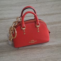 a small red purse sitting on top of a wooden table