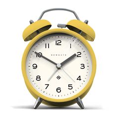 a yellow alarm clock sitting on top of a white table next to a black handle