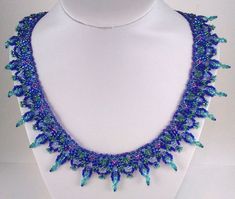 a necklace with blue and green beads on a white mannequin