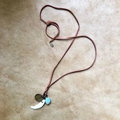 "-This earthy unisex necklace features a coyote tooth, a Peruvian blue opal stone, and an antique wheat penny. -The trio hangs from adjustable deerskin leather lace, which is 30\" from end to end. Just tie the leather in a bow or knot at the desired length. -Layers well with longer necklaces and looks great on men or women. -Dates on antique coins will vary. -Each opal stone and tooth are unique. Opals may vary in size and color, but each are beautiful and hand-picked by the designer. -No animal Animal Teeth, Peruvian Blue Opal, Tooth Necklace, Antique Coins, Peruvian Opal, Unisex Necklace, Deer Skin, Opal Stone, Opal Necklace