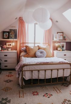 a bed room with a neatly made bed and two white lamps above the headboard