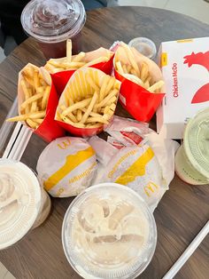 french fries, ketchup, and other food items are on a wooden table