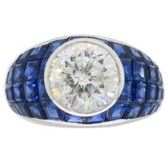 Vintage approximately 2.62CT Round Brilliant Cut diamond ring with blue sapphires set in a mosaic design crafted in platinum Gemstone: Diamond and Sapphire Gemstone Size: Irregular Cut Blue Sapphires ranging from approximately 2.00-2.4mm in size Center Diamond Carat Weight: Approximately 2.62CT Center Diamond Cut: Round Brilliant Cut Center Diamond Color: H-I Center Diamond Clarity: I1 Metal: Platinum Ring Size: 6.5 Marked/Tested: Stamped "PLAT" Weight: 12.2 Grams Luxury Modern Sapphire Ring With Single Cut Diamonds, Luxury Multi-stone Sapphire Ring In Platinum, Sapphire Ring Vintage 1stdibs, Luxury Sapphire Diamond Ring With Diamond Cut, Luxury Platinum Sapphire Ring With Vvs Clarity, Luxury Sapphire Ring In Platinum With Vvs Clarity, Luxury Vvs Clarity Sapphire Ring In Platinum, Luxury Sapphire Multi-stone Diamond Ring, Luxury Brilliant Cut Platinum Gemstones