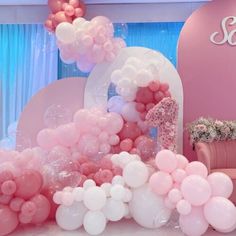 pink and white balloons are on display in the room