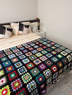 a crocheted bedspread on top of a bed in a room with white walls