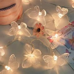 the fairy lights have been placed next to a book and a flower on top of it