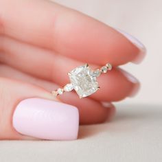 a woman's hand holding an engagement ring