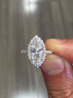 a person holding an engagement ring in their hand with the diamond on it's side