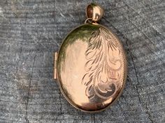 "Set in 9k yellow gold this lavish vintage oval locket is a classic. It dates from the 1940s. Beautifully engraved on one side, this is the essence of elegance. It opens up and has room for 2 pictures. The locket measures 1 3/4\" x 1\". It weighs 12.25 grams. N 659 SIX MONTH LAYAWAY AVAILABLE" Elegant Antique Gold Oval Locket Necklace, Vintage Gold Locket Necklace With Oval Link, Vintage Gold Oval Link Locket Necklace, Vintage Engraved Oval Pendant Locket Necklace, Timeless Gold Oval Locket Necklace, Vintage Engraved Oval Locket Necklace, Gold Engraved Jewelry For Vintage Events, Elegant Rose Gold Oval Locket Necklace, Engraved Gold Jewelry For Vintage Events