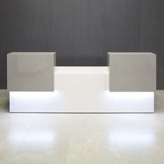 a white counter sitting on top of a tiled floor next to a gray and white wall