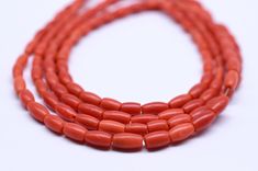 three strands of coral beads on a white background