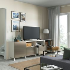 a living room filled with furniture and a flat screen tv on top of a wooden cabinet