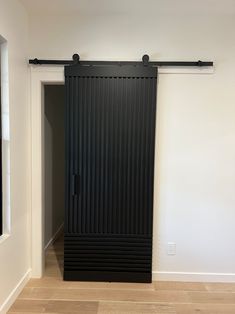 an empty room with a black sliding door