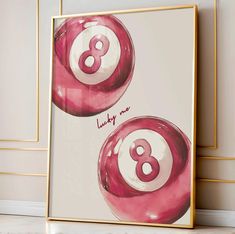 two pink pool balls with the number eight on them in front of a white wall