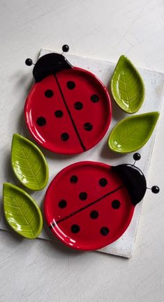 three red and green plates with ladybugs on them