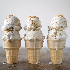 three ice cream cones with toppings sitting on a table