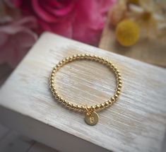 "THIS ITEM SHIPS FOR FREE! Introducing the Petite Initial Charm Bracelet. This listing is for one gold-filled bracelet made with 4mm beads with a hand-stamped initial charm. The charm is petite and measures 3/8\". Please review all of the photographs to see how the charm compares in size to a dime. This is the perfect way to add a little something to your gold-filled bead bracelet. I especially like this tiny charm for tweens/teens or when you want to add multiple charms to your bracelet. Please Dainty Handmade Gold Beaded Bracelets, Dainty Gold Bracelets With Gold Beads, Gold Beads Stretch Bangle Bracelet As Gift, Handmade Stretch Bracelet With Gold Round Beads, Handmade Gold Stretch Bracelet With Round Beads, Handmade Gold Bracelet With Round Beads, Handmade Gold Bracelet In 14k Gold Filled, Dainty Gold Bead Bracelet, Dainty Gold Beaded Bracelet