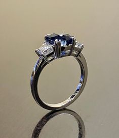 "DeKara Designs Collection Beautiful Modern/Art Deco Ceylon Blue Sapphire and Diamond Ring Metal- 90% Platinum, 10% Iridium Stones- Genuine Cushion Cut Ceylon/Sri Lanka Royal Blue Sapphire 2.87 Carats. Two Trapezoid Cut Diamonds G-H Color VS1 Clarity 0.93 Carats. Size-6. FREE SIZING Entirely Handmade, Classic and Timeless Art Deco Inspired Ceylon Cushion Cut Royal Blue Sapphire Diamond Engagement Ring. This ring is out of this world with the center Ceylon Sapphire being exceptional in quality, c Blue Sapphire Diamond Wedding Ring, Blue Sapphire Diamond Ring For Wedding, Blue Sapphire Ring With Asscher Cut Center Stone, Blue Sapphire Ring For Wedding, Blue Asscher Cut Sapphire Ring With Diamond Cut, Blue Center Stone Wedding Jewelry, Blue Asscher Cut Sapphire Ring With Center Stone, Blue Wedding Jewelry With Center Stone, Blue Gemstone Promise Rings