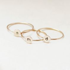 One gold letter ring. Personalize a gift she'll treasure with our gold initial ring. An adorably petite initial, imprinted on a 14k gold filled disk - paired with a super skinny (1mm) gold filled band - creates the perfect stacking ring, customized with your monogram. Lovely as a stand alone. Also sits beautifully with multiple initials stacked or our hammered gold stacking ring bands. This gold initial ring arrives custom made to order in your size hand stamped with the letter of your choice. A Gold Stackable Rings With Initials For Everyday, Everyday Gold Stackable Rings With Initials, Everyday Stackable Yellow Gold Rings With Initials, Personalized Yellow Gold Initial Ring For Everyday, Everyday Personalized Yellow Gold Initial Ring, Dainty Gold Stackable Rings With Initials, 14k Gold Stackable Rings With Initials, Simple Gold Stackable Initial Ring, Dainty 14k Gold Stackable Initial Ring