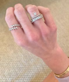 a woman's hand with three different rings on her left and two diamond ring on the right