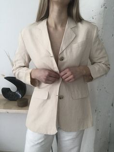 Minimalist oversized cream button down women's blazer with shoulder pads. The perfect vintage linen blazer. Looks great with high waisted pants or worn open over a tank! Size: Women's 4 (model is a S/4) Measurements: shoulder: 17 1/4" | bust: 40 1/2" | length: 28 3/4" Material: 55% Linen | 45% Rayon | Lining 100% Acetate - this piece has shoulder pads! Condition: Excellent Measurements are taken with the garment lying flat, from seam to seam, and doubled where appropriate. If you need any additi Elegant Everyday Blazer With Button Closure, Vintage Cream Blazer For Workwear, Vintage Blazer For Business Casual In Spring, Beige Linen Blazer With Hidden Buttons, Spring Single Breasted Everyday Blazer, Beige Single Button Blazer For Spring, Beige Linen Blazer For Workwear, Cream Business Blazer For Spring, Beige Linen Blazer For Work