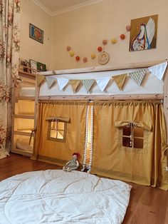 there is a bunk bed with a tent on the top and curtains over it in this room