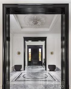 an elegant entry way with marble floors and black framed doors