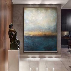 a large painting hanging on the wall in a living room next to a table and chairs